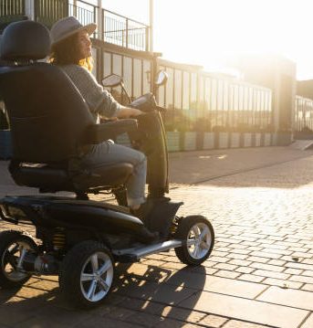 Woman wearing hat on a mobility scooter